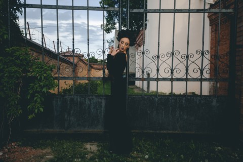 Middle Eastern woman wearing black dress near gate