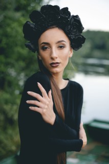 Middle Eastern woman wearing black dress in boat on lake