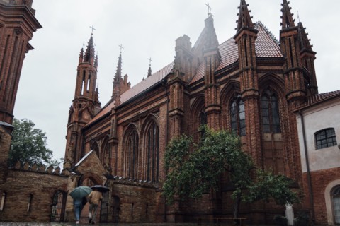 People carrying umbrellas near church