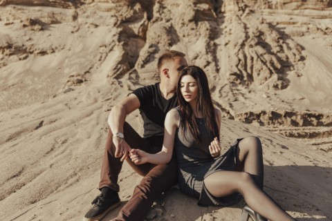 Middle Eastern couple sitting in desert