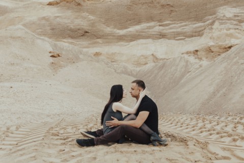 Middle Eastern couple cuddling in desert
