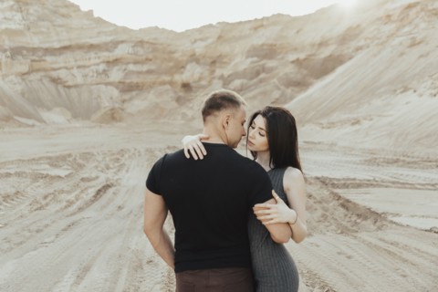 Middle Eastern couple kissing in the desert