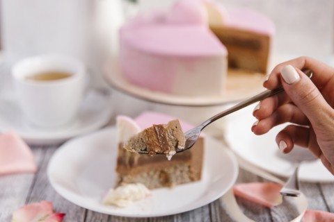 Hand of woman holding cake on fork