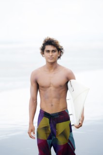 Man carrying surfboard on beach