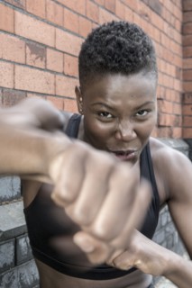Black athlete punching outdoors