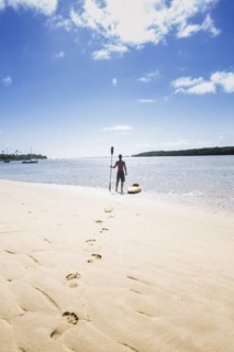Native American man with kayak on beach