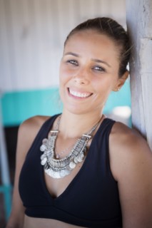 Smiling hispanic woman wearing necklace and bikini