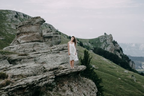 Caucasian woman standing on rock overlooking landscape