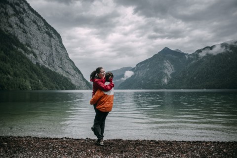 Caucasian man hugging near mountain lake