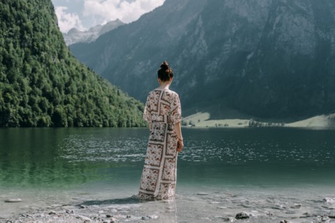 Caucasian woman wading in mountain lake