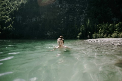 Caucasian woman swimming in mountain lake