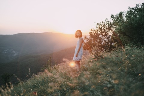 Serious Caucasian woman standing on mountain