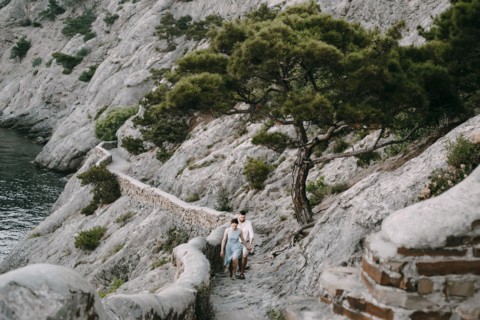 Caucasian couple hiking on cliff near lake