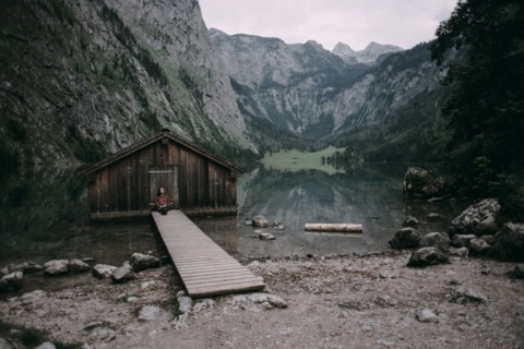 Caucasian woman sitting on dock at remote cabin