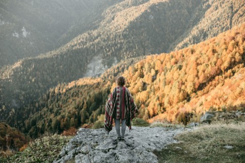 Caucasian woman standing on mountain overlooking valley