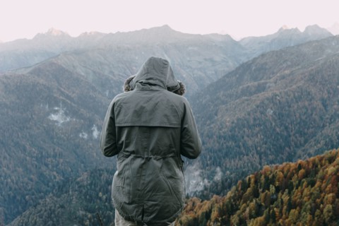 Caucasian man wearing coat looking at valley
