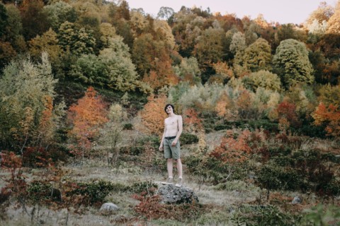 Caucasian man standing on rock in autumn