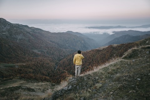 Caucasian man standing in remote mountain landscape