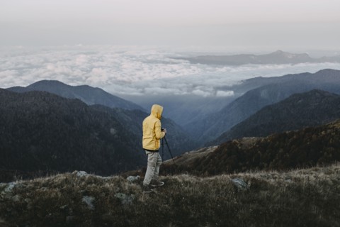 Caucasian man photographing in remote mountain landscape