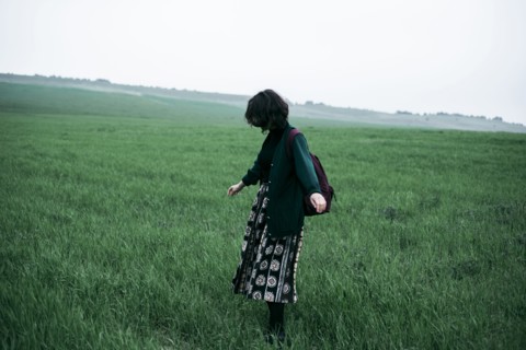 Caucasian woman standing in field of grass