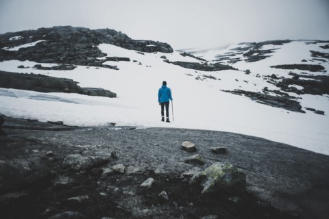 Distant Caucasian man hiking in winter