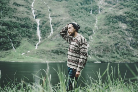 Pensive Caucasian man standing near river