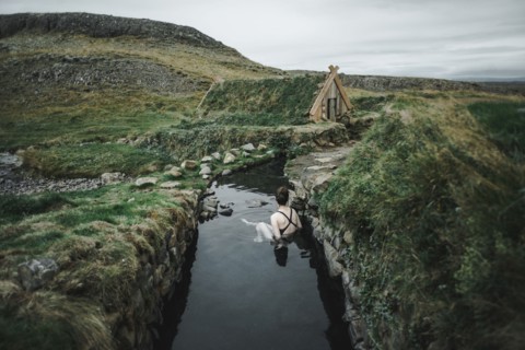 Caucasian woman swimming in pond near rural house