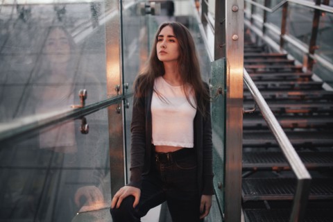Pensive Caucasian woman at window near staircase