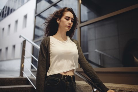 Wind blowing hair of pensive Caucasian woman on staircase