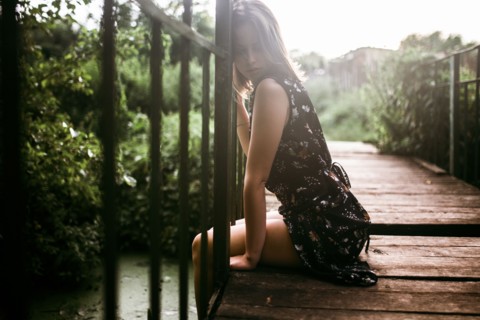 Caucasian woman sitting on wooden bridge