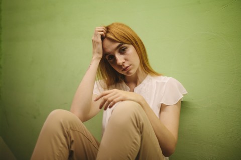Pensive Caucasian woman leaning against wall