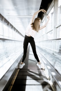 Caucasian woman dancing on moving walkway