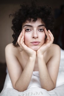 Portrait of serious Caucasian woman laying on bed
