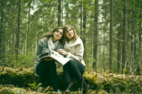 Caucasian women reading magazine in forest