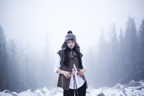 Caucasian woman standing in snowy woods