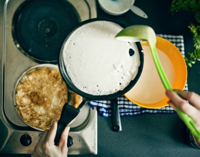 Woman making pancakes in kitchen
