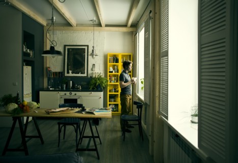 Caucasian man looking out kitchen window