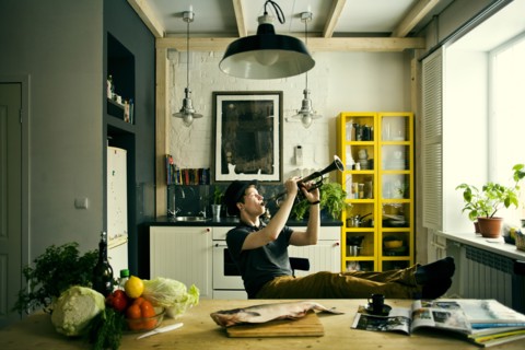 Caucasian man playing trumpet in kitchen