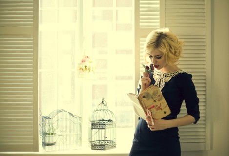 Caucasian woman reading by window