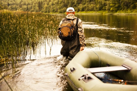 Mari fisherman pulling boat through lake