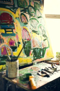 Paint brushes and painting in art studio