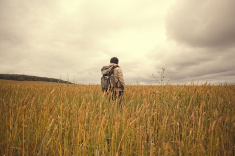 Mari man standing in tall grass in rural field