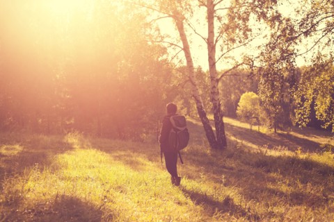 Mari man carrying backpack in rural field
