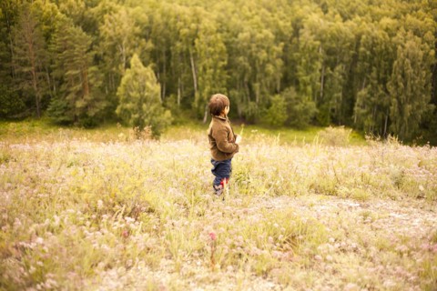 Mixed race boy standing in rural field