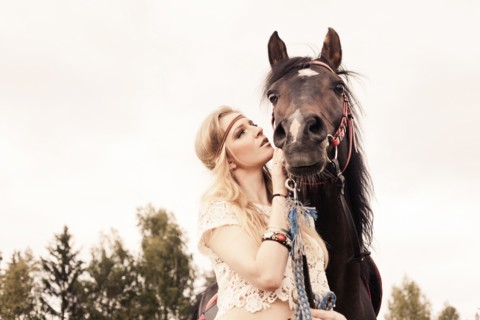 Caucasian woman petting horse outdoors