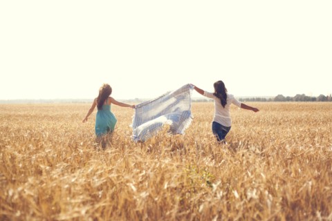 Caucasian women carrying blanket in rural field