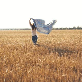 Caucasian woman carrying blanket in rural field