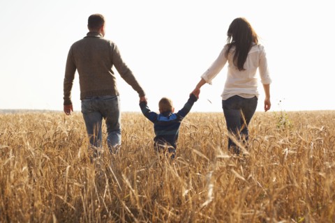Caucasian family walking in rural field
