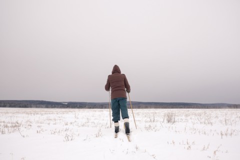 Woman cross-country skiing in snowy field