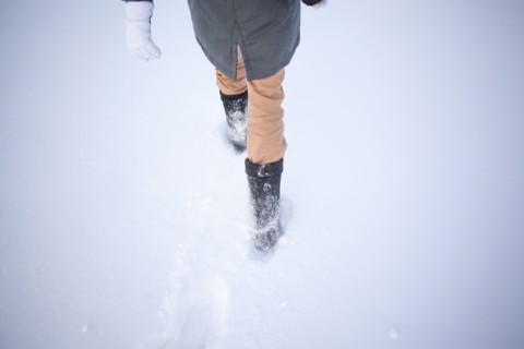 High angle view of Caucasian woman walking in snowy field